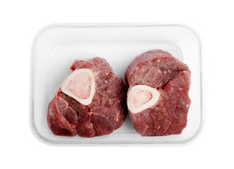 Frozen beef steaks in container isolated on white, top view