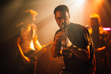 Trumpet player performing live on stage with band