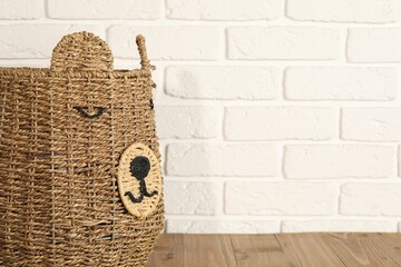 One wicker laundry basket on wooden table, space for text