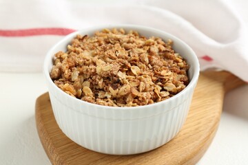 Delicious apple crisp in bowl on white table, closeup