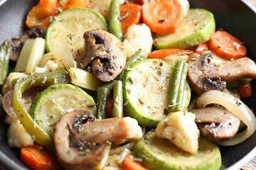 Different vegetables and mushrooms in frying pan, closeup