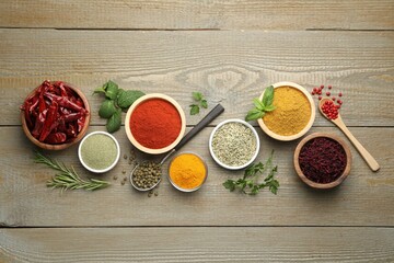 Different aromatic spices on wooden table, flat lay