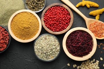 Different aromatic spices on black table, flat lay