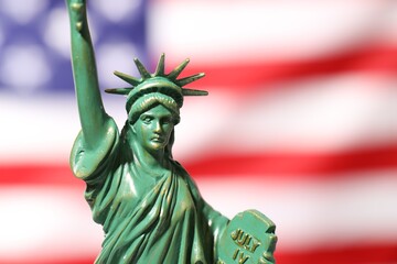 Fototapeta premium Statue of Liberty against flag of USA, closeup. Space for text