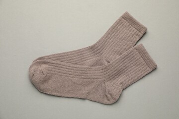 Pair of soft socks on light grey background, top view
