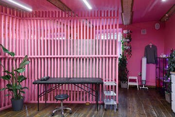 The Tattoo Studio Interior is Vibrantly Pink, Featuring an Abundance of Plants and Modern Decor