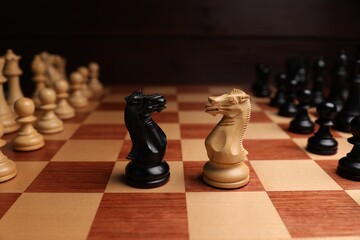 Black and white chess knights in middle of chessboard, closeup. Competition concept © New Africa