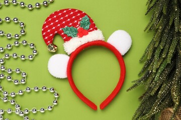 Stylish party headband and Christmas decor on green background, flat lay
