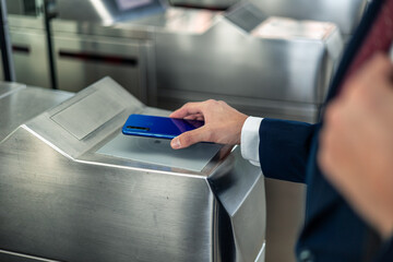copyspace closeup a businessman’s hand using contactless mobile payment to access the metro station © EDER