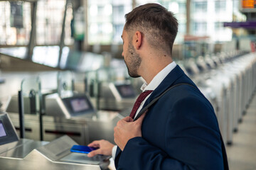 closeup businessman using mobile for contactless payment at train station turnstiles © EDER