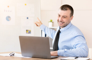 Distant Work. Businessman At Laptop Making Video Call Communicating With Employees Sitting In Modern Office