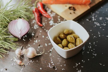 Fresh red salmon on a wooden tray with pepper, salt, garlic, red onion, red pepper, olives with jam