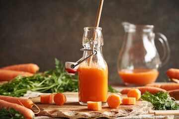 A bottle of fresh carrot juice with ecological paper straw. Zero waste.
