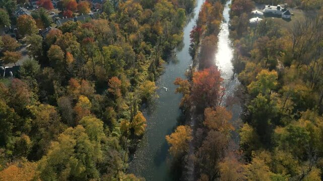 Aerial view of Fall foliage along a peaceful river, drone 4K