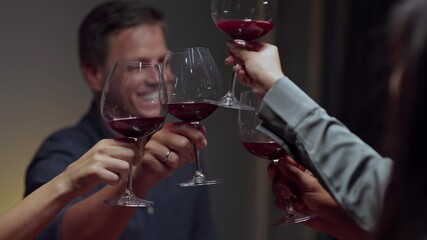 Close-up shot of diverse group of friends sitting at the restaurant table and making a toast in slow-motion - Powered by Adobe