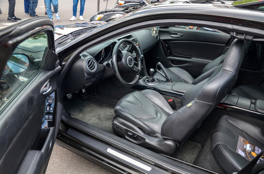 Spacious of Mazda RX-8 car interior featuring sleek black leather seats and stylish dashboard The open door view highlights the vehicle's luxurious and contemporary design