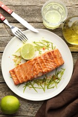 Delicious grilled salmon fillet served on wooden table, flat lay