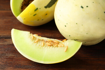 Fresh ripe honeydew melons on wooden table, closeup