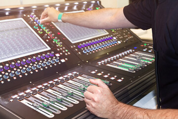 Sound engineer hands adjusting control sound mixer in recording, broadcasting studio