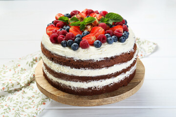 Delicious chocolate sponge cake with berries on light table