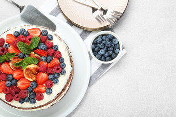 Delicious chocolate sponge cake with berries served on light table, flat lay. Space for text