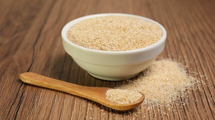 Oat bran in bowl and spoon on wooden table, closeup