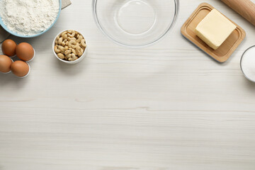 Different ingredients for cookies on white wooden table, flat lay. Space for text