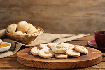Tasty cashew cookies with powdered sugar on wooden table, closeup