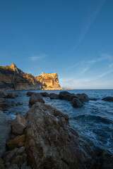 The rock rises above the blue sea