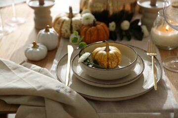 Stylish table setting with beautiful dishware and autumn decor in dining room