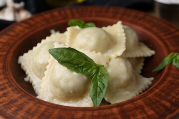 Delicious ravioli with cheese and basil served on table, closeup