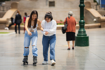 Obraz premium Young woman helping her disabled friend learning to skate in a city park
