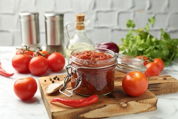 Spicy salsa and ingredients on white table