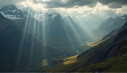 Lichtstrahlen brechen durch Wolken über gebirgiger Landschaft

