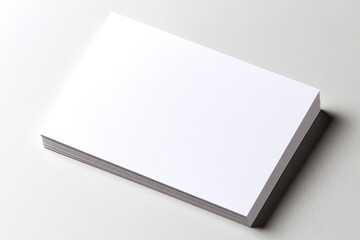 A white business card with a stack of white cards on top of it