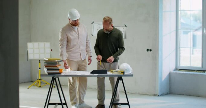 Discussion of the house construction plan. Joint work of the customer and the foreman