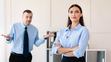 Sexism At Workplace. Businessman Shouting At Woman Employee Standing In Modern Office. Selective Focus