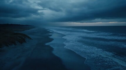 Fototapeta premium A serene coastal scene at dusk, featuring dark clouds and gentle waves.