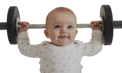 Baby lifting weights with a cheerful expression, cut out - stock png.