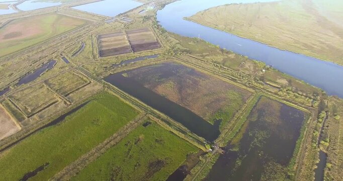 Summer evening. Bird eye view, dollyshot.Endless green fields with lakes