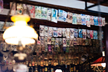 Unique Collection of Global Currency Hanging in a Vintage Cafe Decor Captures the Essence of International Exchange and Cultural Diversity