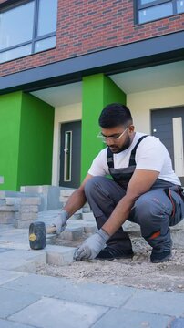 Construction worker fixing the pavestone on patio