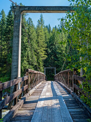 Fototapeta premium Wooden footbridge across the Lochsa River on the Eagle Mountain Trail near Powell Junction, Idaho, USA