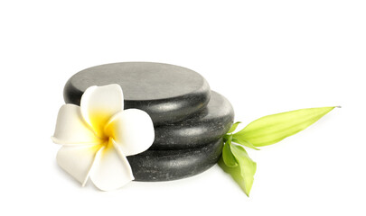 Spa stones, plumeria flower and green leaves isolated on white