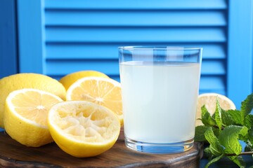 Fresh juice in glass, lemons and mint on table, closeup