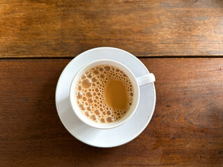 Top view of a cup of milk tea or teh tarik on wooden table