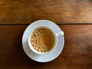 Top view of a cup of milk tea or teh tarik on wooden table