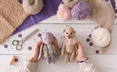 Process of making vintage toy, top view. Artisan pov, needlewoman hands holding handmade teddy bear...