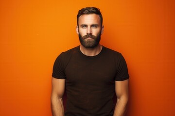 Obraz premium portrait of a man with a beard against a vibrant orange background