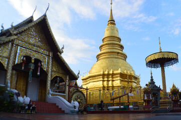Naklejka premium Church and Golden Pagoda Lanna Architecture in night at Wat Phra That Hariphunchai ,Symbols of Buddhism, at Lamphun Northern Thailand,South East Asia